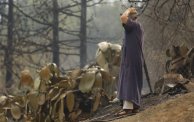 رجل يقف على مخلفات النيران بولاية البوية (الصورة: Getty)